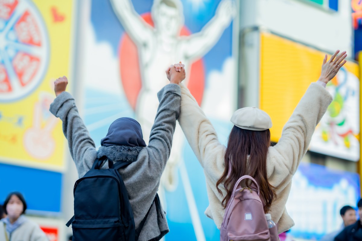 woman girl tourist Two Asian friends but different religions, one of whom is a Muslim girl. walking traveller shopping street food at Dotonbori or dotombori Shinsaibashi, Osaka City, Osaka, Japan.