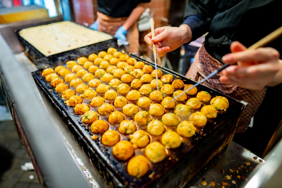 process to cooking takoyaki most popular delicious street food at Dotonbori or dotombori, Dotonbori the famous destination for traveller in Shinsaibashi, Osaka City, Osaka, Japan.