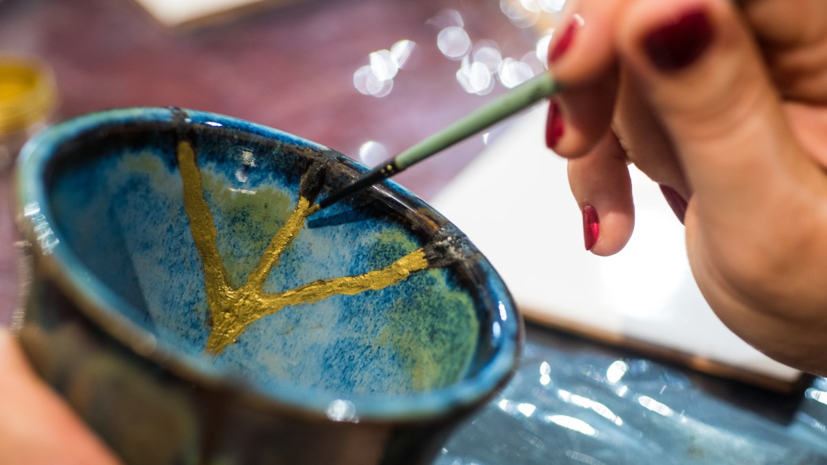 Female hands fixing porcelain with kintsugi method