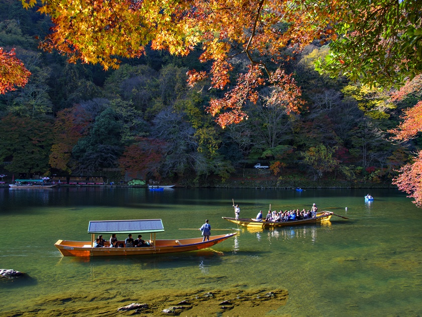 Japan - November 26, 2016 : Tourist Boats run along Hozugawa River in Autumn at Arashiyama, Kyoto