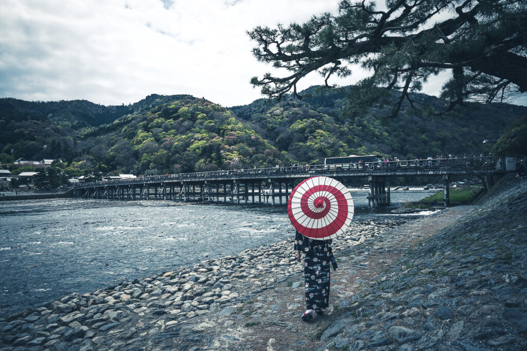 渡月橋を眺める和傘の着物女性