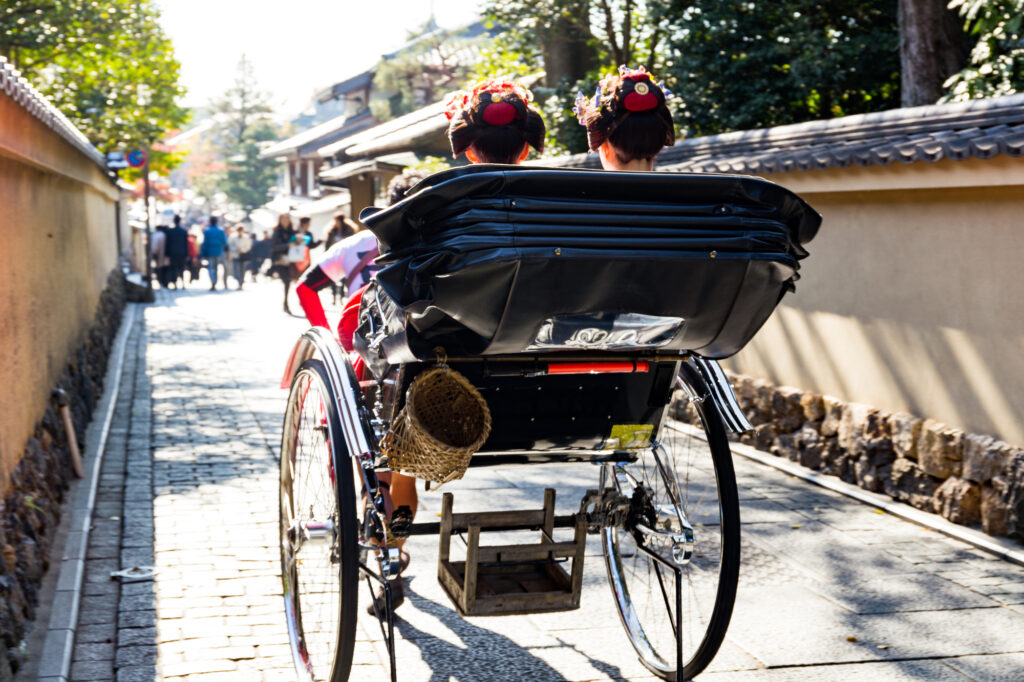 人力車に乗って京都の街並みを行く舞妓さん