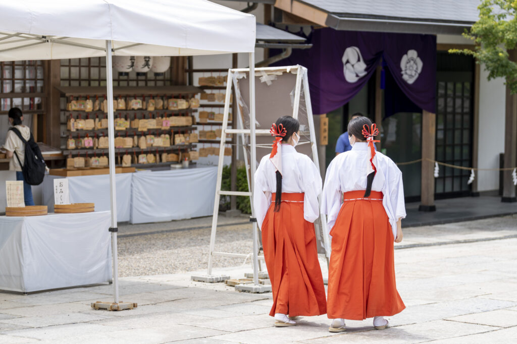 神社の境内を歩く二人の巫女
