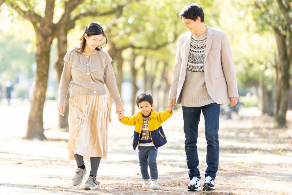 子供と手をつないで歩く家族