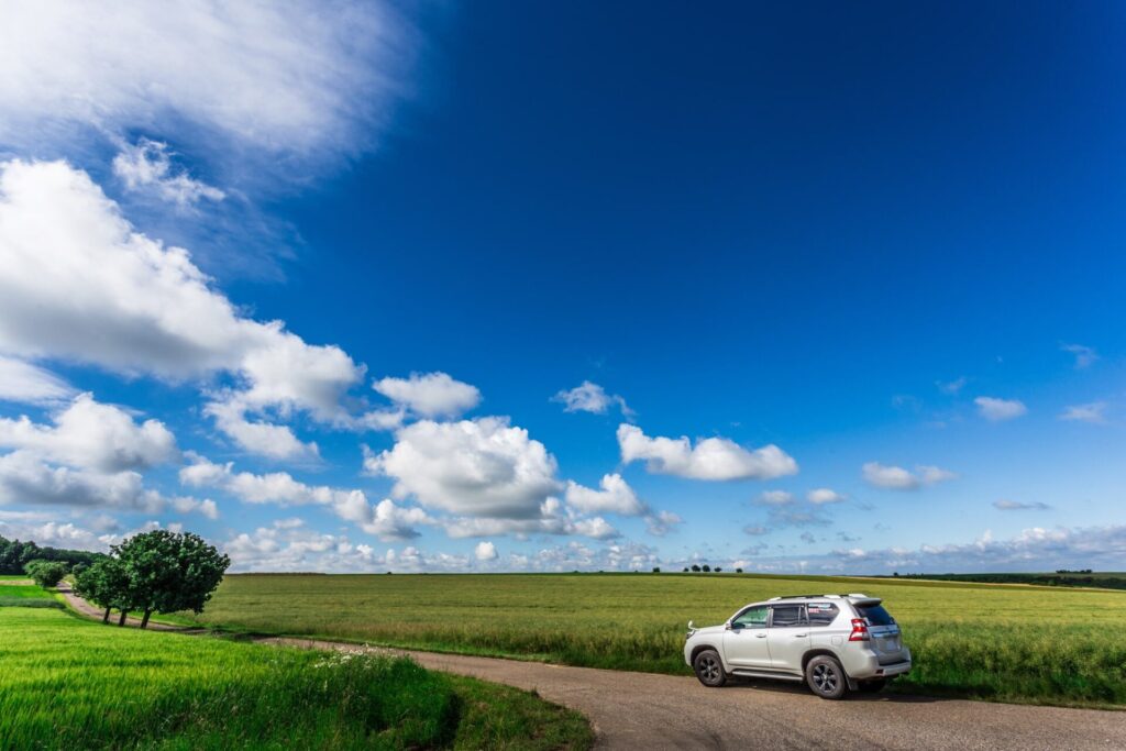 青空の元ドイツのロマンチック街道をドライブする車