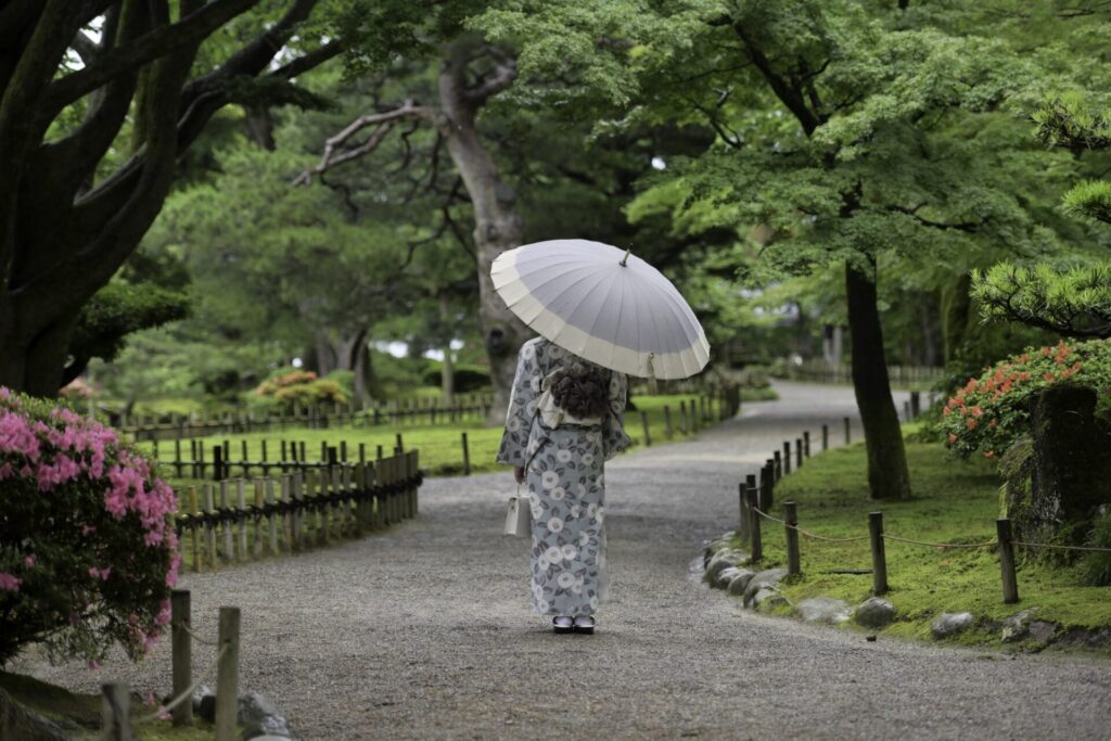 小雨降る兼六園を散策する着物女子