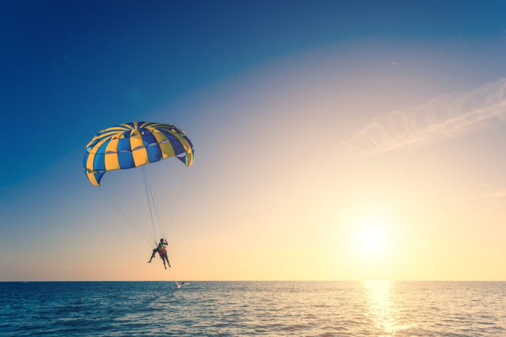 夕焼けの海でパラセーリング
