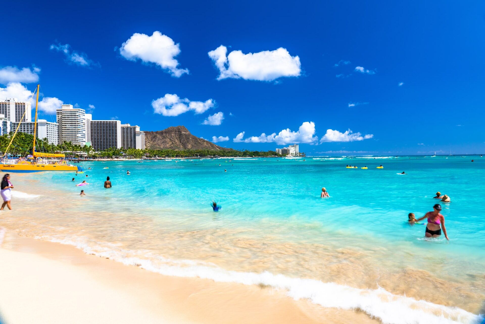 ワイキキビーチで海を楽しむ観光客