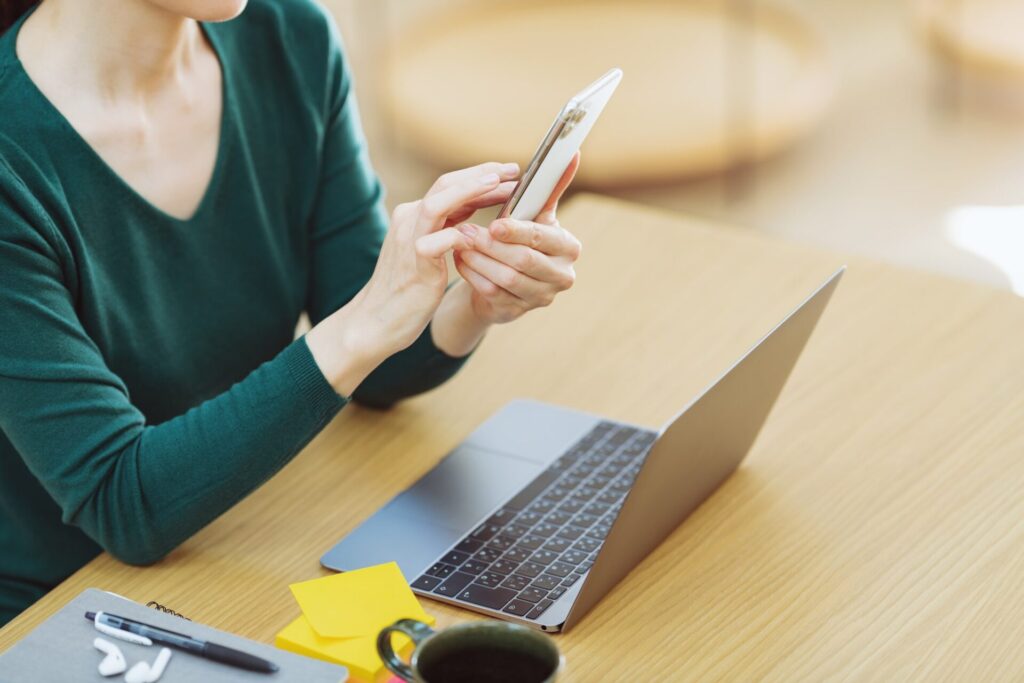 スマホとパソコンを操作する女性の手元