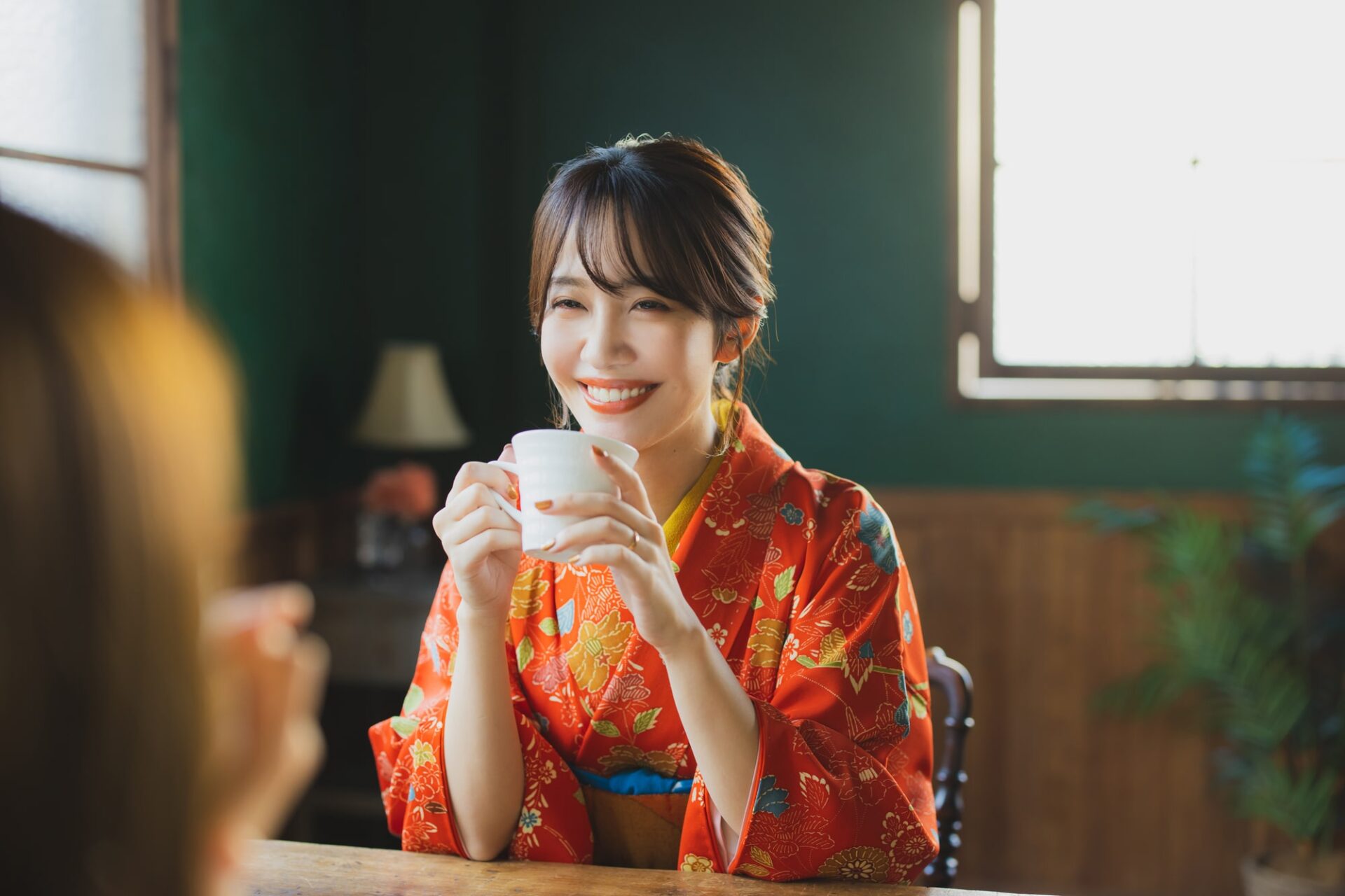 着物で友人とカフェを楽しむ女性