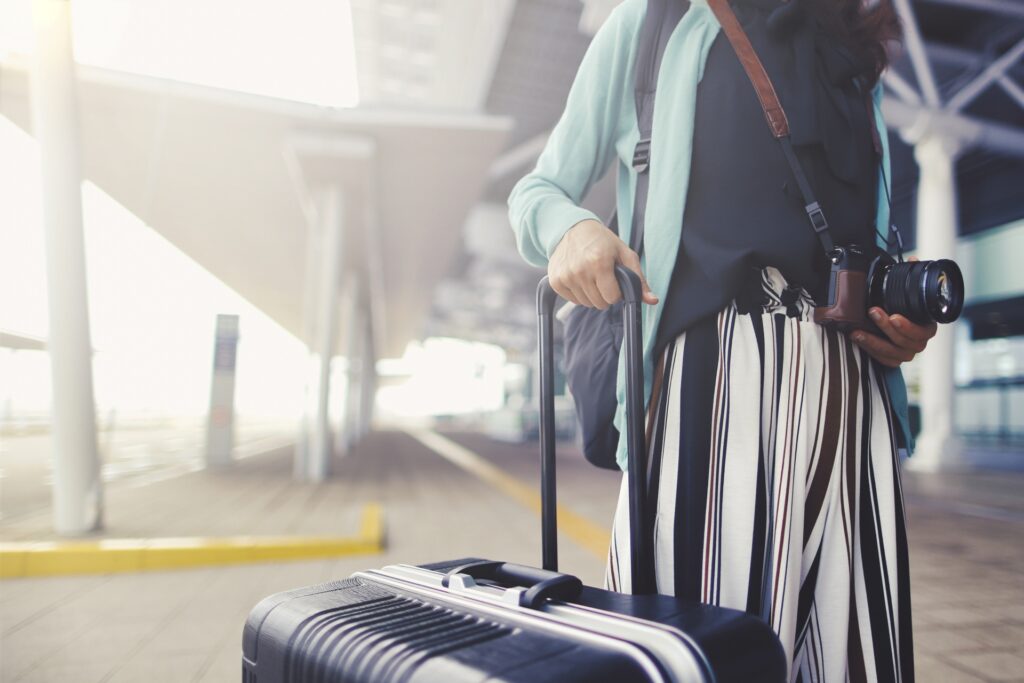 スーツケースを持って駅へ移動する女性