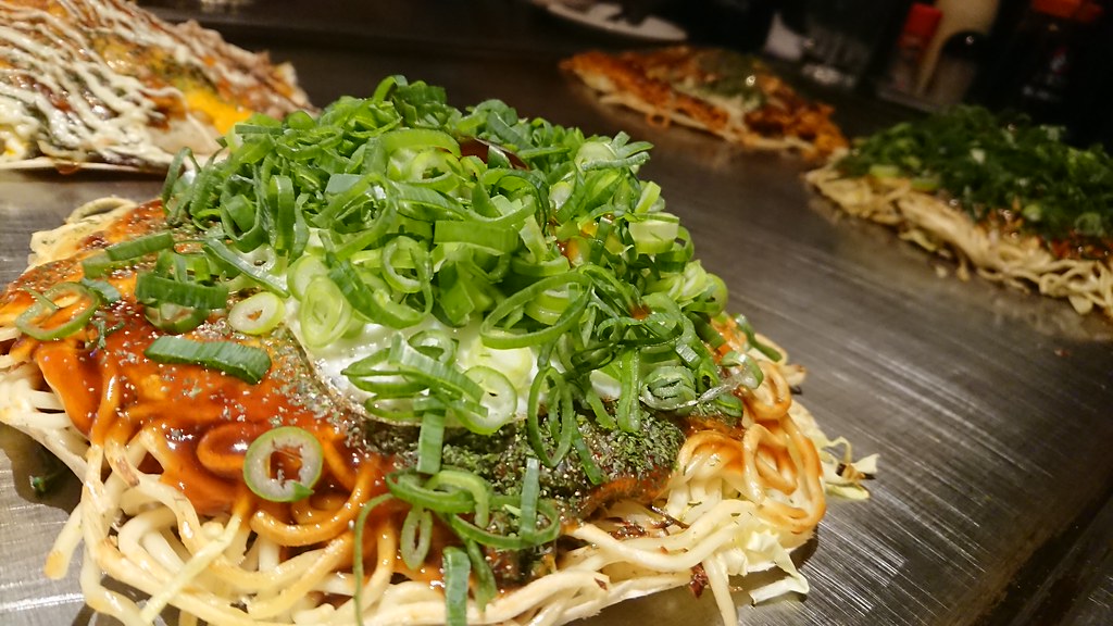 鉄板でやかれたアツアツの広島名物であるお好み焼き