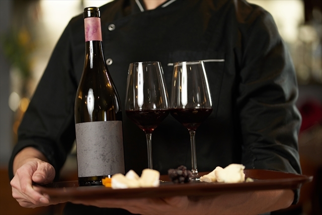 レストランでワインを給仕する人