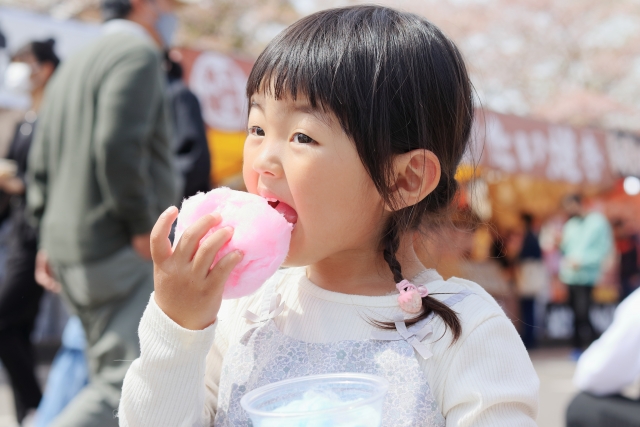 祭りで綿あめを食べる子供