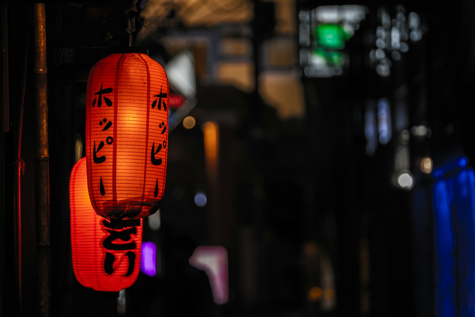 a couple of red lanterns hanging from the side of a building