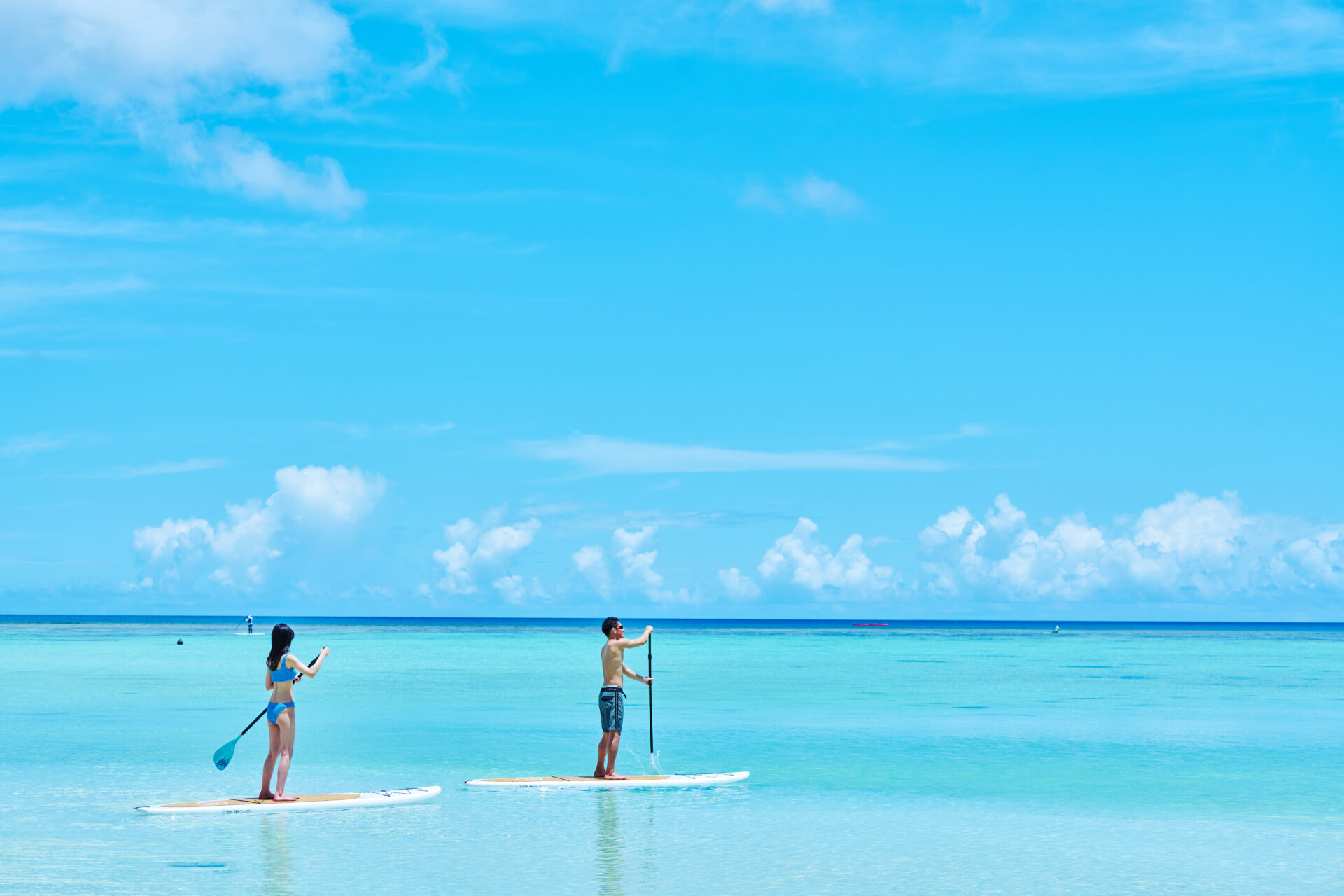 日本から近い海外・グアムで楽しみたい、SUP体験をしり男女と美しい海の様子