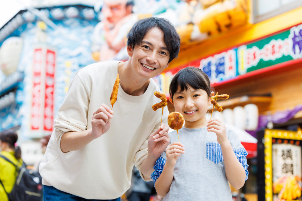 大阪で食べ歩きをする親子